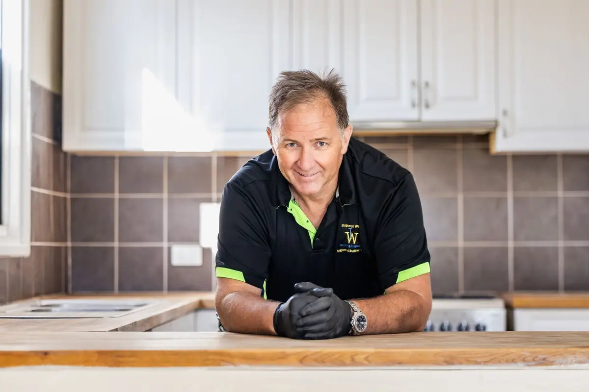 Brian Collins, Inspector West building inspector, leaning on a kitchen bench on site in Perth