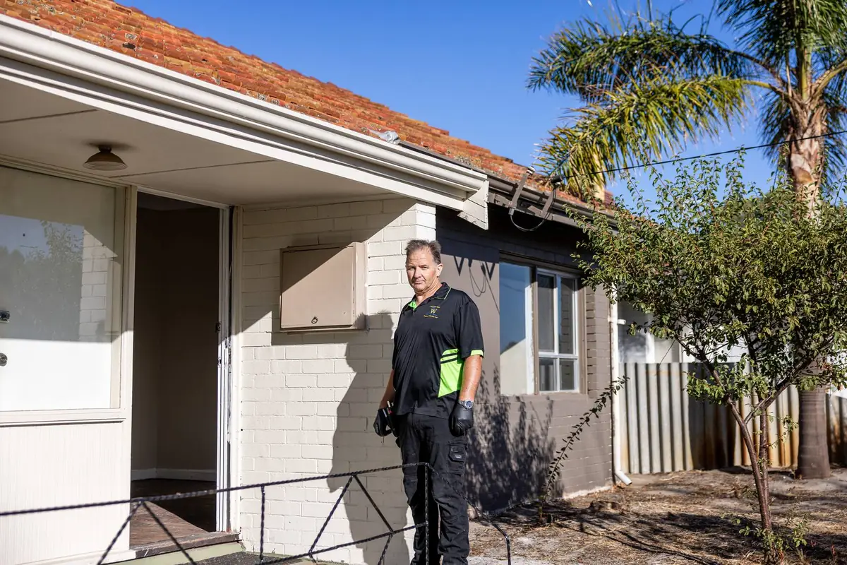 Building inspector at the front of an established brick home before an inspection in Bunbury