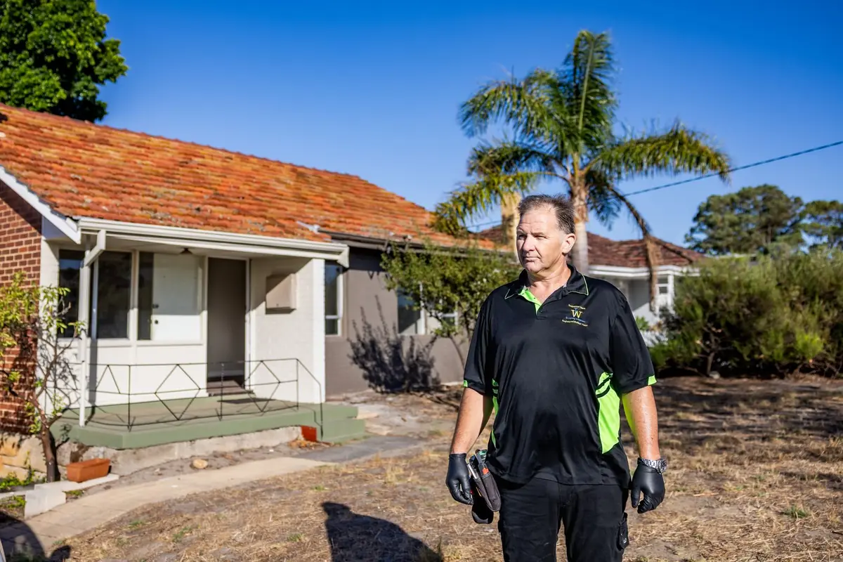 Building inspector standing outside a brick home before a building inspection in Joondalup