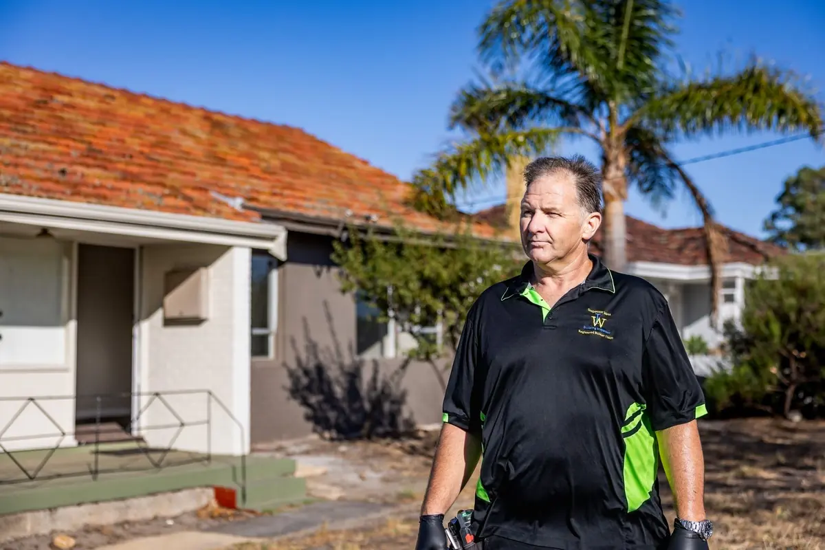 Building inspector Brian Collins on site outside a brick and tile home in Perth