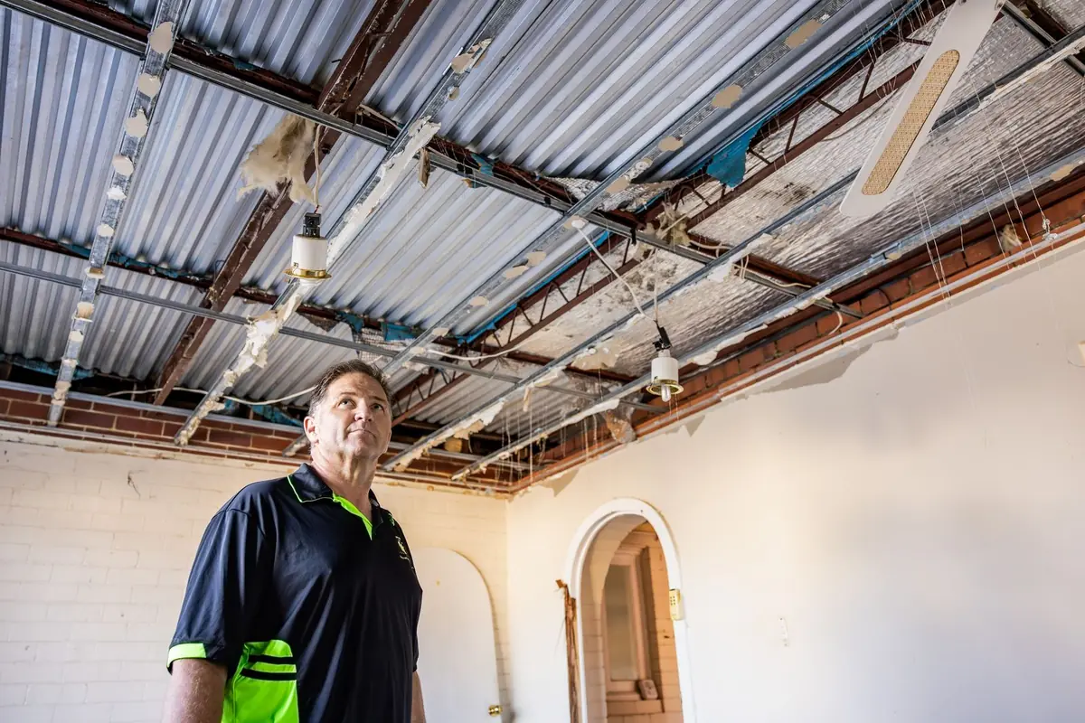 Building inspector looking over exposed roof framing during an owner-builder inspection in Perth