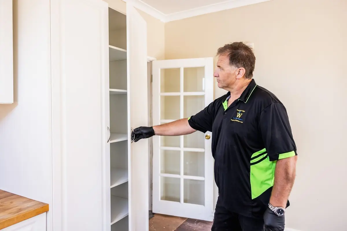 Building inspector checking built-in cupboards during an internal building inspection in WA